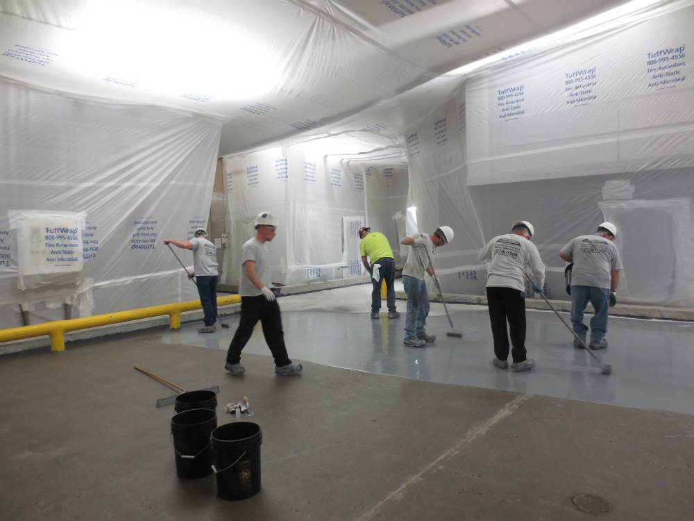 PermaFloor's crew at work efficiently coating the area and broadcasting slip resistant aggregate.