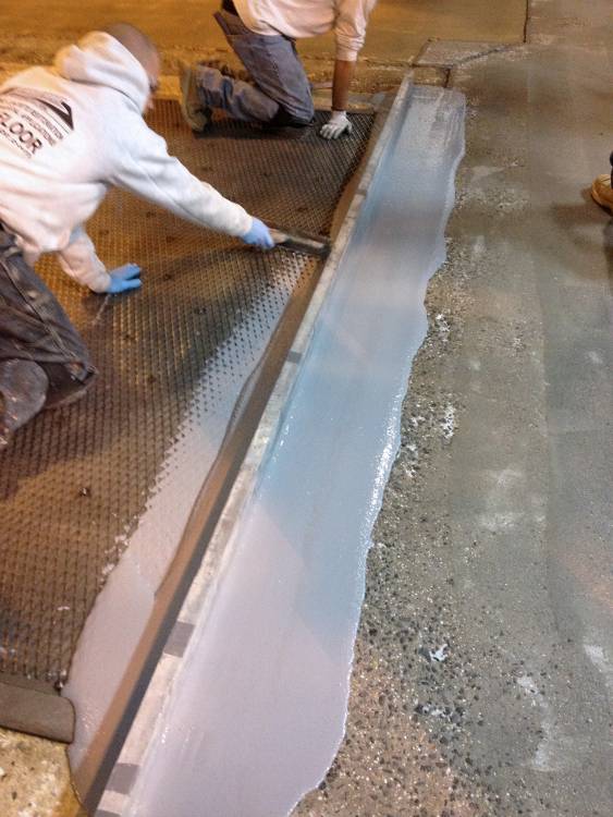 Urethane concrete is applied to the screen and used to patch damaged areas nearby.